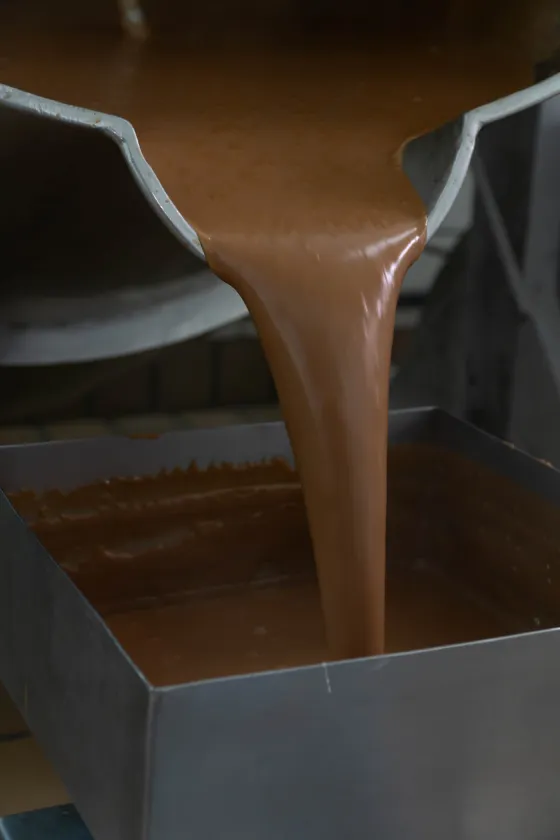 Doce de leite sendo despejado durante a produção