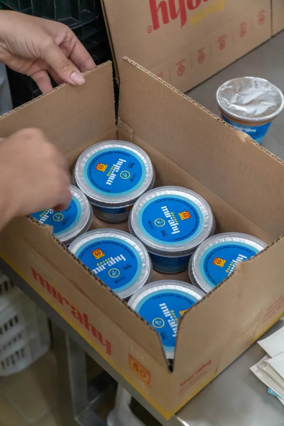 Potes de doce sendo encaixotados para expedição